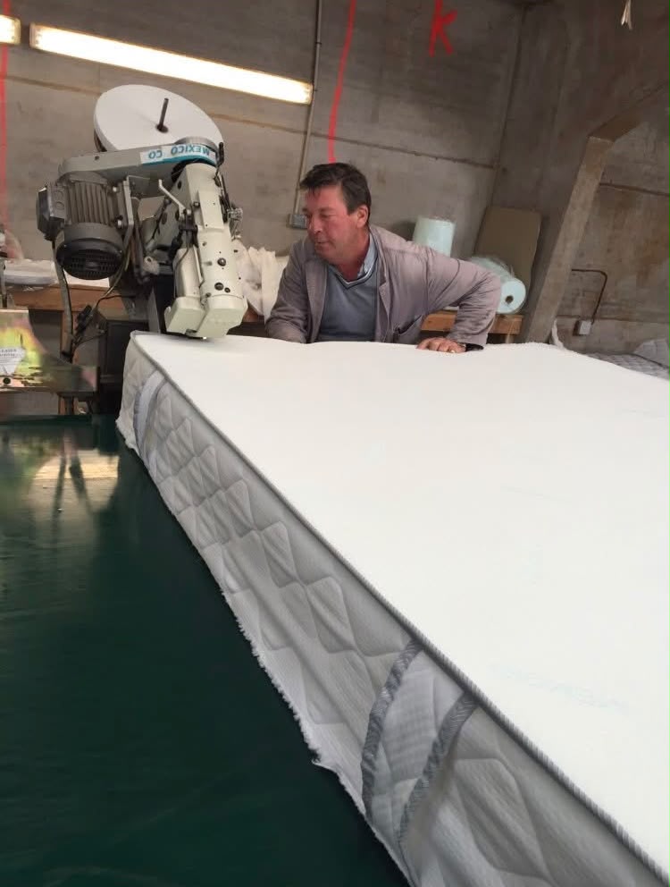 Artisan matelassier fabriquant un matelas à la main